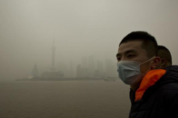 A man wears a face mask while walking on the Bund in front of the financial district of Pudong during a hazy day in downtown Shanghai December 9, 2013. A man wears a face mask while walking on the Bund in front of the financial district of Pudong during a hazy day in downtown Shanghai December 9, 2013.