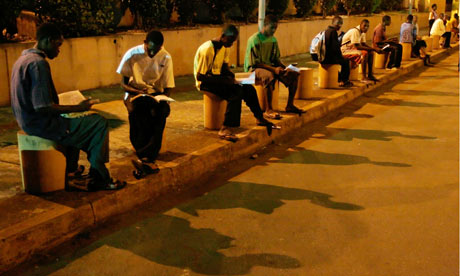 Young Guineans, without access to electricity, study under carpark lights at G'bessi airport in Conakry, Guinea. Photograph: Rebecca Blackwell/AP Young Guineans, without access to electricity, study under carpark lights at G'bessi airport in Conakry, Guinea. Photograph: Rebecca Blackwell/AP